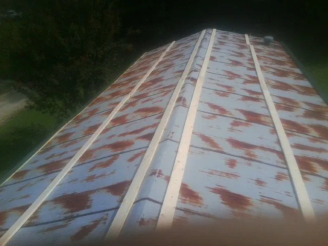 Rusted metal roof panels with new wood purlins before replacement — Storm Damage Roof Repair in Uehling by Roofing Brothers