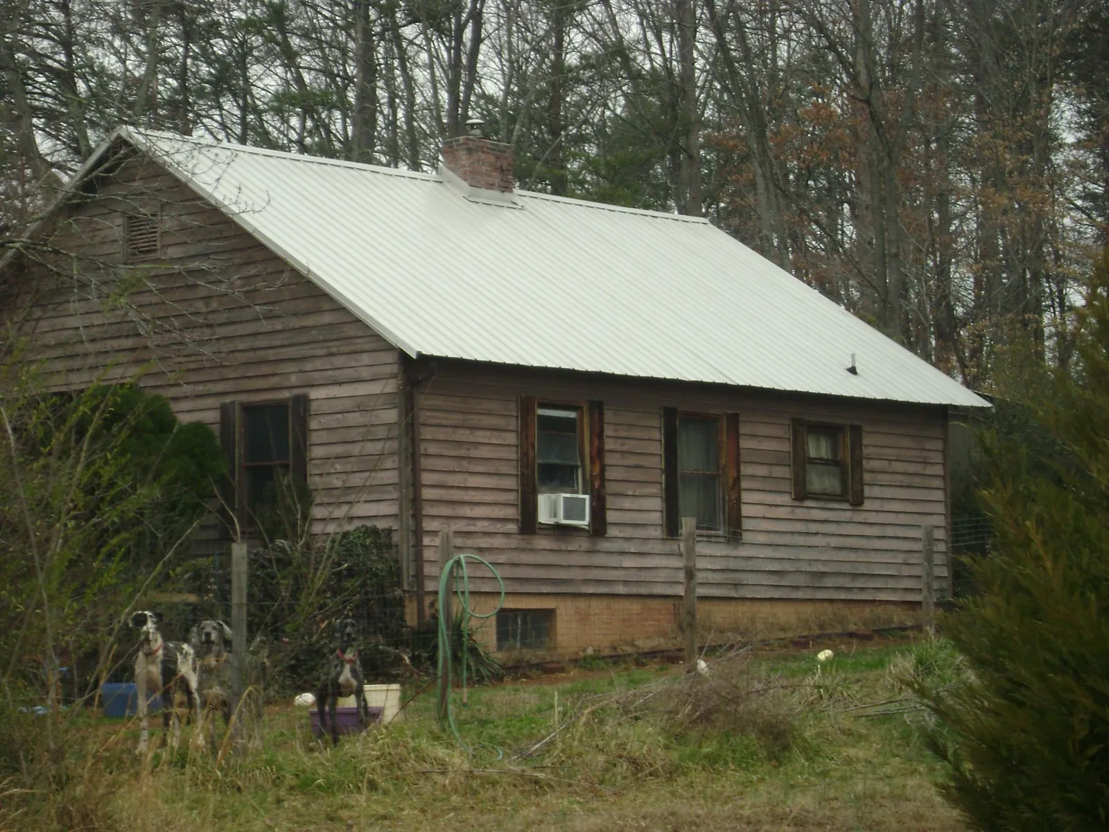 White metal roof on an old wood sided farmhouse, from a Metal Roof Installation job in Uehling